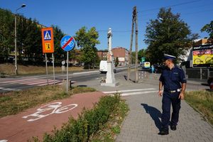 zdjęcie archiwalne, policjant z drogówki podczas kontroli przy przejściu dla pieszych obok szkoły