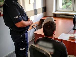 Policjant, w trakcie czynności z zatrzymanym kierowcą.