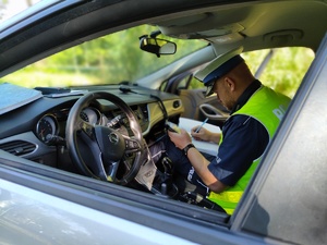 Policjant siedzący w radiowozie w trakcie czynności służbowych