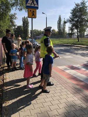 zdjęcie policjanta z dziećmi ze szkoły nr 35 przy przejściu dla pieszych
