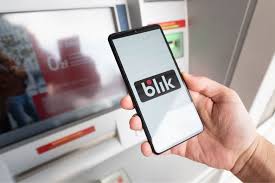 zdjęcie bankomatu i telefonu z wyświetlonym logo usługi blik