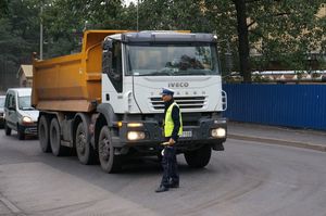 zdjęcie poglądowe - policjant na ulicy stoi przed ciężarówką