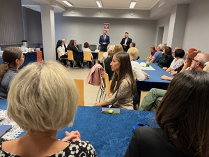 zdjęcie - sala w której zgromadzili się pracownicy cywilni Policji, na końcu widać stojącego komendanta składającego podziękowania zebranym pracownikom