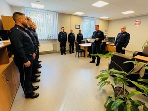 zdjęcie z gabinetu komendanta, policjanci do mianowania stojący w szeregu, komendant, jego zastępca i przełożeni policjantów stojący obok