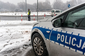 zdjęcie poglądowe - policjant na drodze przy padającym śniegu