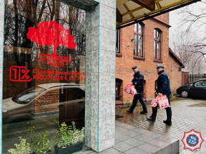 zdjęcie - policjanci ze świątecznymi torbami wchodzą do budynku świetlicy środowiskowej