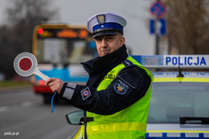policjant drogówki z tarczą do zatrzymywania pojazdów