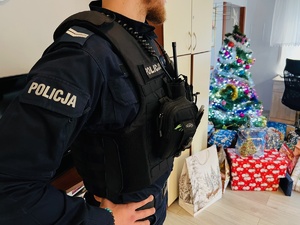 zdjęcie przedstawia policjanta stojącego przy choince