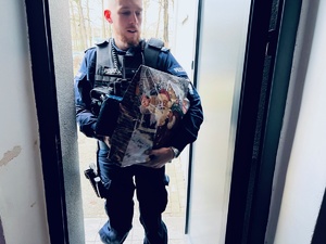 zdjęcie przedstawia policjanta niosącego prezenty