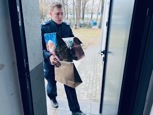 zdjęcie przedstawia policjanta niosącego prezenty