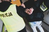 zdjęcie poglądowe policjantów prowadzących zatrzymanego