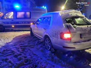 zdjęcie radiowozu i samochodu osobowego zimą