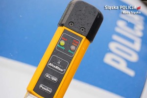 zdjęcie poglądowe - policyjny alkotest na tle radiowozu