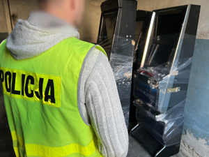 zdjęcie przedstawiające policjanta przy zabezpieczonych nielegalnych automatach