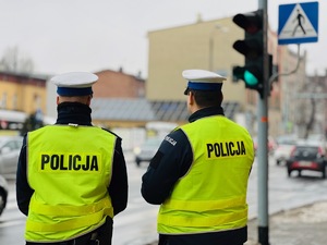 zdjęcie przedstawia policjantów przy przejściu dla pieszych z sygnalizacją świetlną
