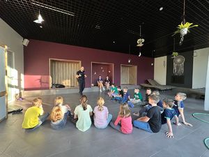 Dzieci w trakcie rozmowy z policjantem, w jednym z pomieszczeń parku wodnego.