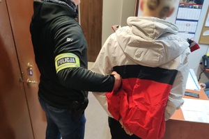 zdjęcie przedstawia policjanta po cywilu z zatrzymanym 18-latkiem