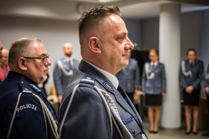odchodzący na emeryturę policjant, przy nim stoją inni policjanci