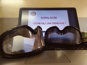 Alkogogle i narkogogle, a w tle laptop z prezentacją.