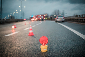 zdjęcie ilustracyjne - droga, światła ostrzegawcze, policjanci pracujący w miejscu wypadku