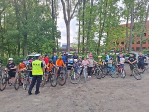 zdjęcie przedstawia rowerzystów i policjanta prowadzącego prelekcję na temat przepisów