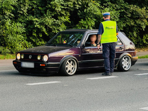 zdjęcie przedstawia policjanta kontrolującego trzeźwość kierowcy