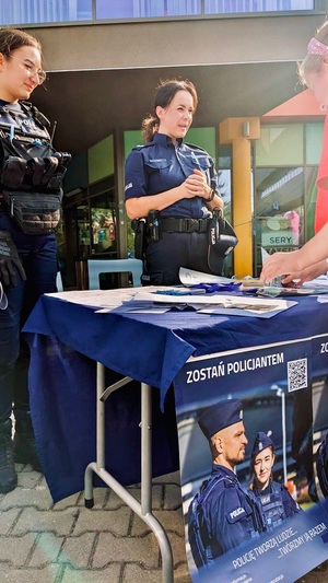 zdjęcie z festynu przedstawiające przygotowane przez policjantów stoisko profilaktyczne przy którym stoją dwie policjantki