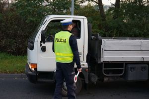 zdjęcie poglądowe - policjant z drogówki podczas kontroli trzeźwości kierowcy samochodu dostawczego