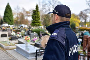 zdjęcie przedstawia policjanta na cmentarzu