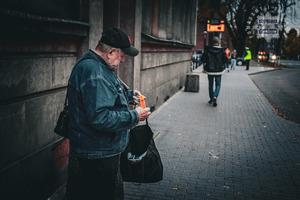 zdjęcie z akcji Świeć przykładem noś odblaski przedstawiające starszego mężczyznę trzymającego w ręku odblaskową opaskę