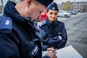 zdjęcie przedstawia policjanta i policjantkę, dowódców zabezpieczenia z dokumentacją