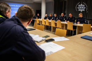 zdjęcie przedstawia salę odpraw komendy, siedzących policjantów ustalających rozdział ról w ćwiczeniach