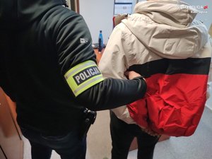 zdjęcie poglądowe, policjant prowadzi zatrzymanego