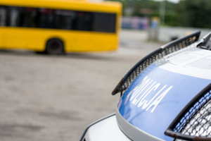 zdjęcie poglądowe policyjnego radiowozu i autobusu w tle