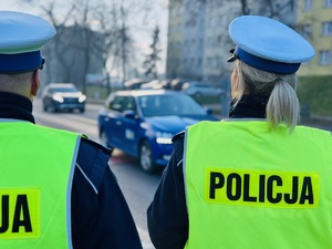 zdjęcie przedstawia policjantów oraz jadące samochody