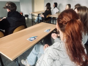 Ulotki i długopisy promujące służbę w policji leżą na szkolnej ławce