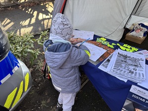 zdjęcie przedstawia dziecko kolorujące rysunek z policjantami