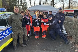 zdjęcie przedstawia wolontariuszy, policjantów i uczniów rudzkiej mundurówki przy stoisku Policji