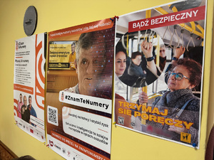zdjęcie przedstawia pomieszczenie koła seniorów, gdzie na ścianie widoczne są plakaty związane z bezpieczeństwem seniorów, w tym plakat akcji trzymaj się poręczy