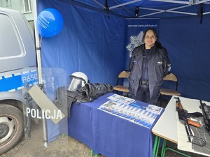 zdjęcie przedstawia policjantkę przy stoisku promującym służbę w policji