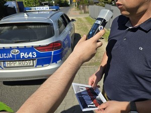zdjęcie przedstawia policjanta i kierowcę z ulotką kampanii