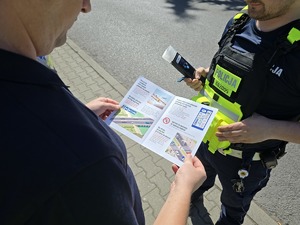 zdjęcie przedstawia policjanta i kierowcę z ulotką kampanii
