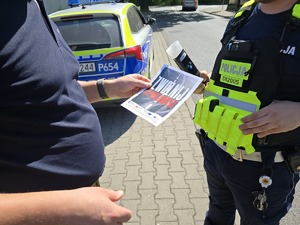 policjanta i kierowcę z ulotką kampanii