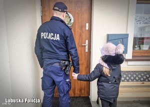zdjęcie policjanta i dziecka stojących przed drzwiami domu