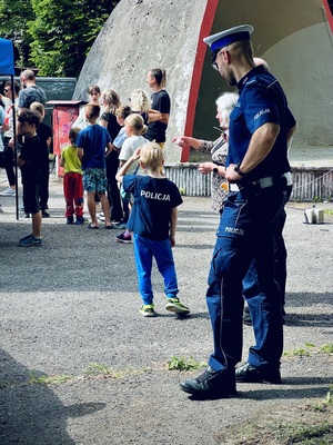 Tłum uczestników wydarzenia, wśród osób znajduję się dziecko, które z tyłu na koszulce ma napis POLICJA
