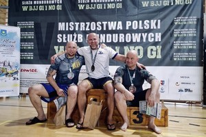 Zdjęcie przedstawia zawodników stojących na podium
