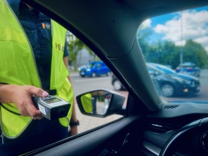 Zdjęcie przedstawia policjantkę trzymającą urządzenie do pomiaru trzeźwości
