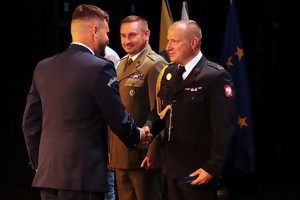 zdjęcie z uroczystości Święta Policji przedstawia moment odznaczenia Komendanta Straży Pożarnej odznaką związkową przez przewodniczącego związków zawodowych