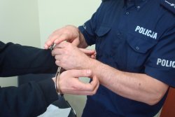 zdjęcie poglądowe - policjant zapina kajdanki na ręce mężczyzny