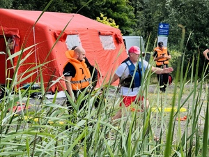 zdjęcie przedstawia ćwiczenia z ratownictwa wodnego gdy policjant wykonuje rzuty zgodnie z instrukcjami ratownika wodnego